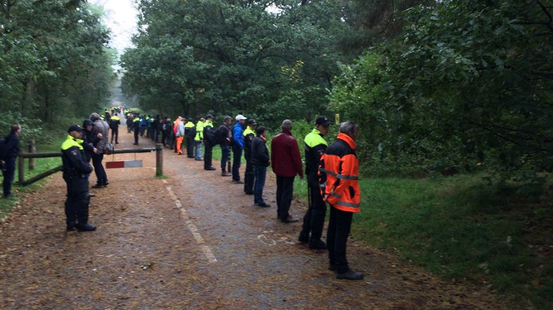 ME en vrijwilligers gaan in linie het bos door