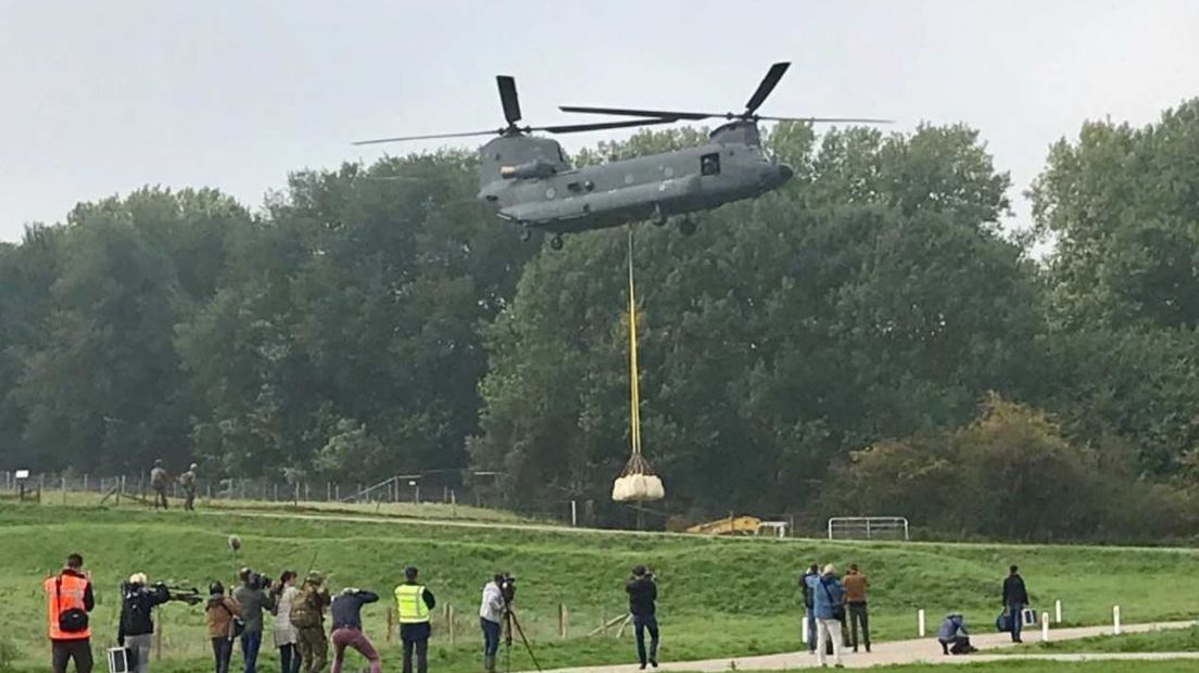 Het is een spectaculair gezicht deze woensdag aan de overkant van de Lek bij Culemborg en de Grebbedijk bij Wageningen. Defensie oefent daar met een Chinook-helikopter op het beschermen van de dijken.