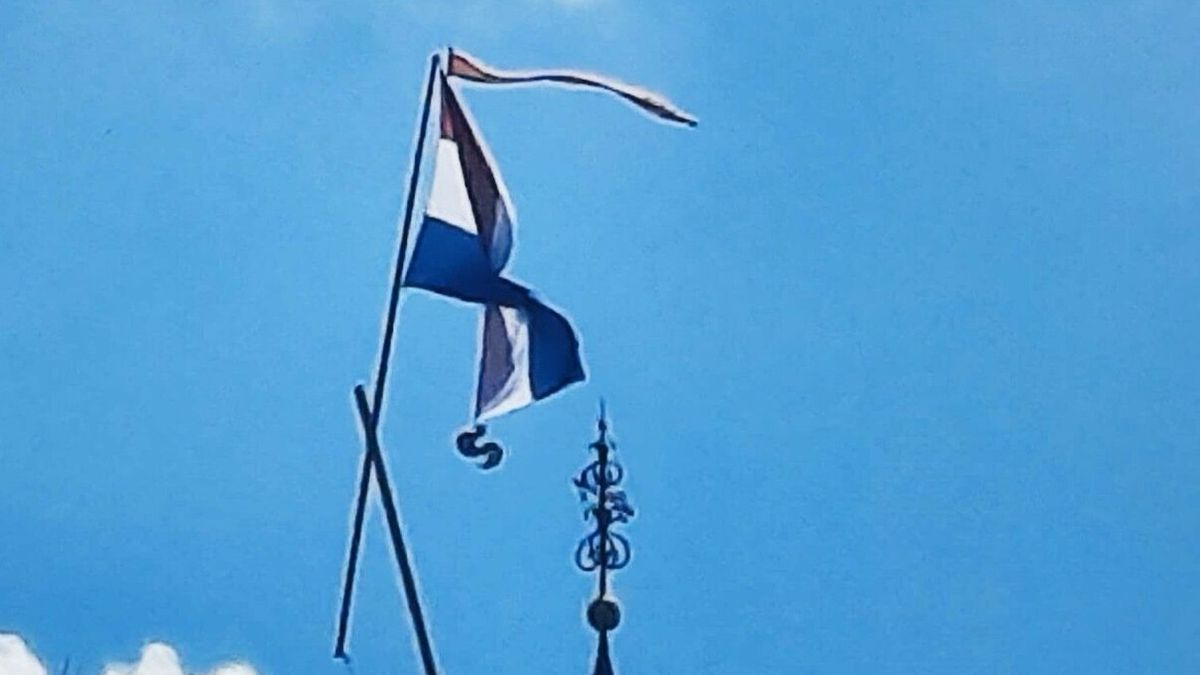 Vlag rukt de haan van de kerktoren van Warten