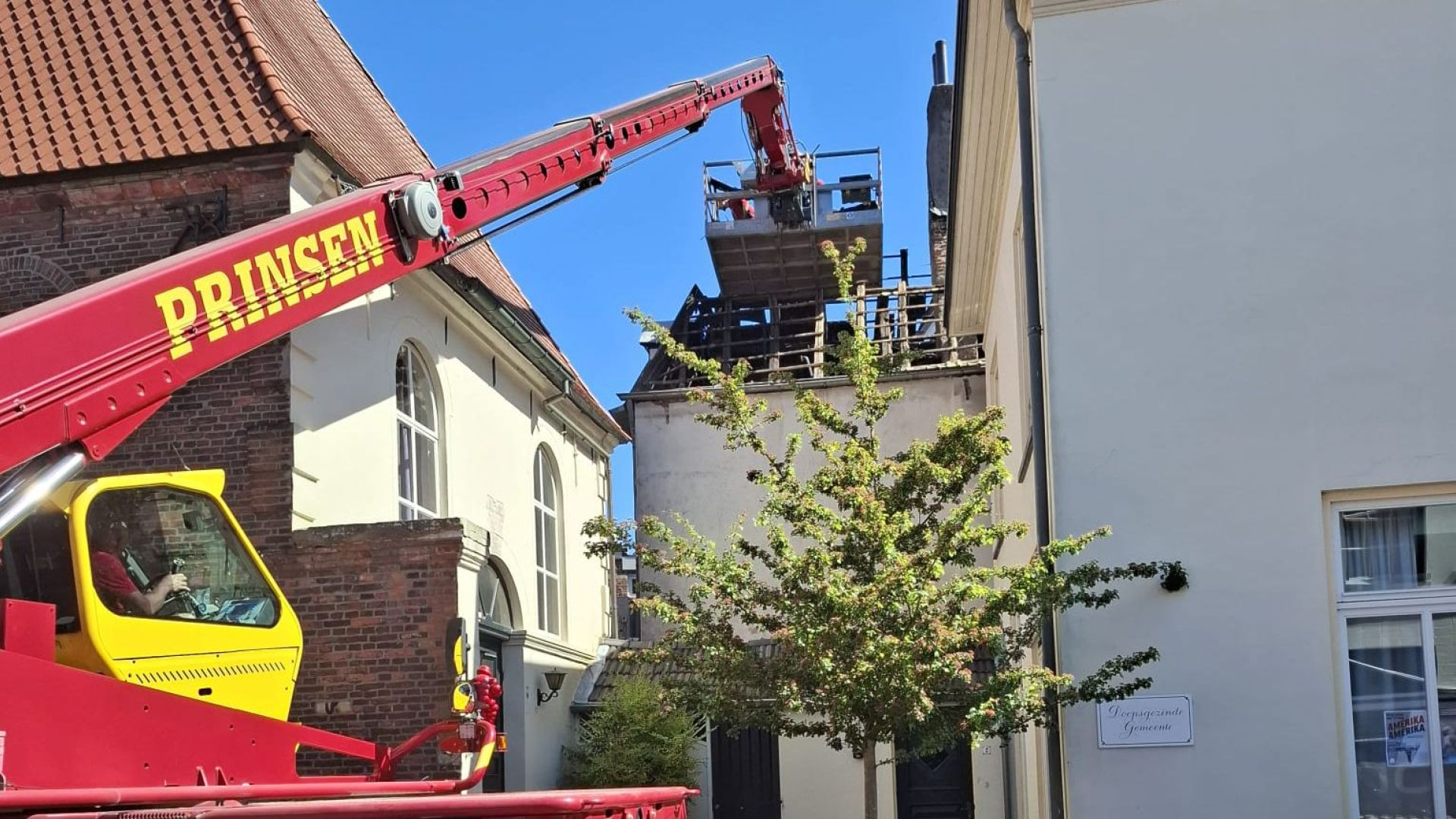 Met een hoogwerker worden de eerste sloopwerkzaamheden van de cafetatia gestart na de grote brand in Winterswijk.
