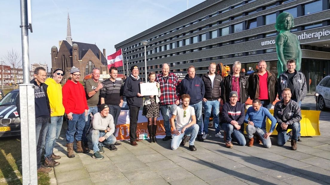 De deelnemers aan de Crazy Car Run bieden de cheque aan.