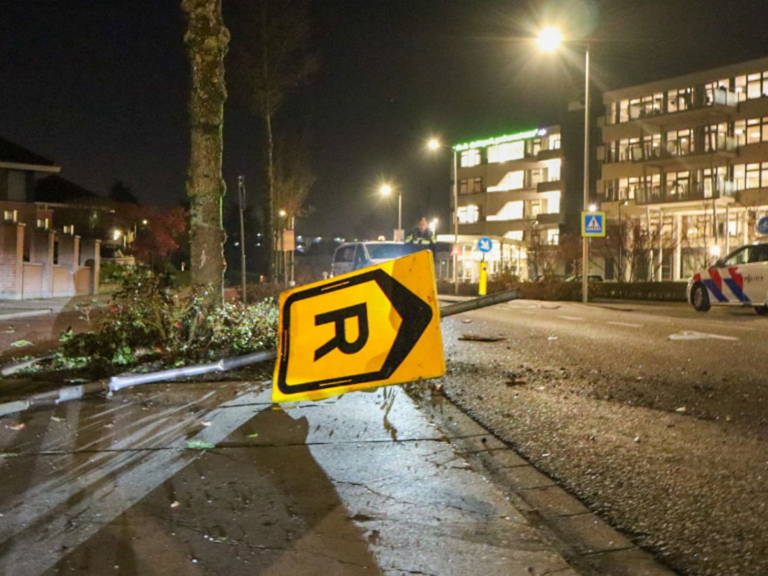 De paal waar de auto tegen reed ligt over de weg.