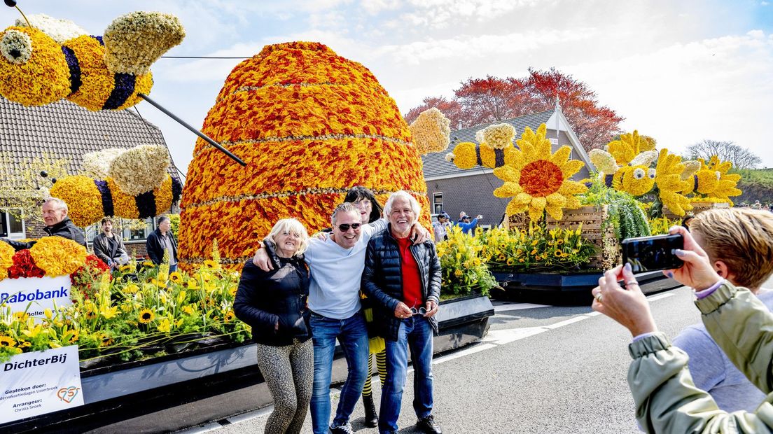 Bezoekers gaan op de foto met een praalwagen tijdens het 75-jarig jubileum van het Bloemencorso van de Bollenstreek