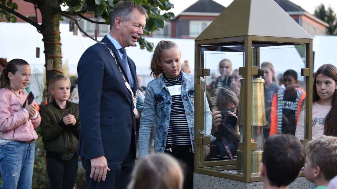 Basisschoolleerlingen ontsteken samen met wethouder Peppelman de vlam.
