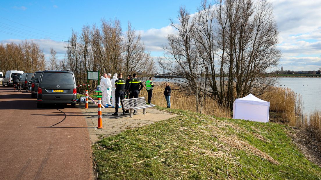 Langs de waterkant staat een witte tent van de politie