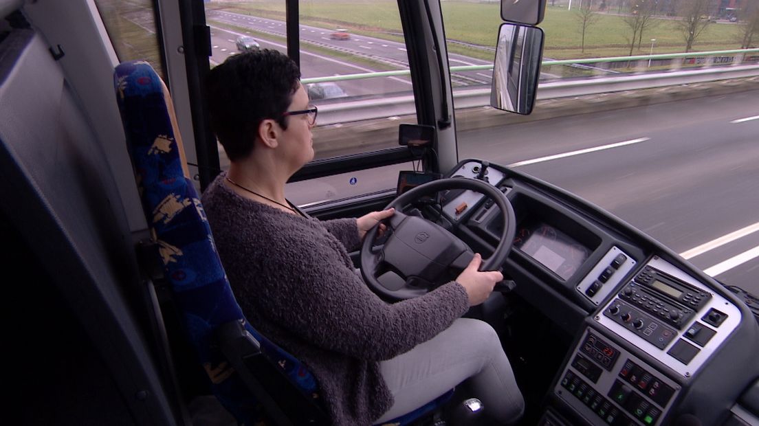 Coby van Sas achter het stuur van een lesbus