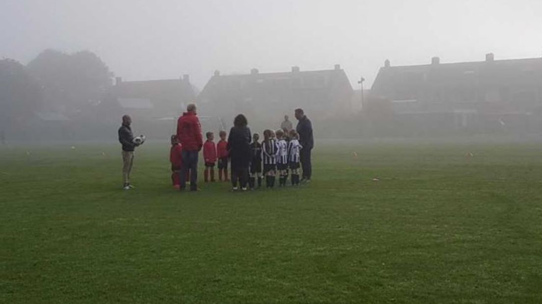 Spelertjes van Eldenia JO9-4G en VDZ JO9-11G nemen een minuut stilte in acht.