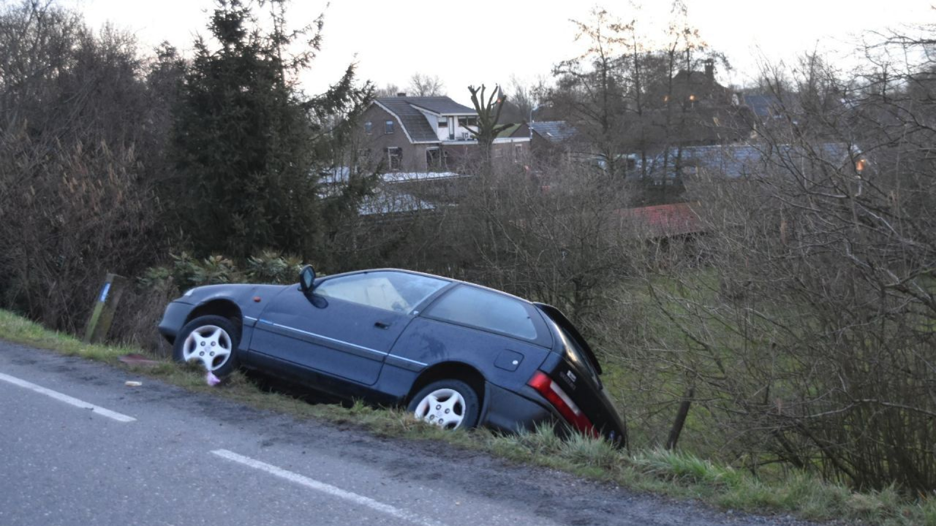 Auto naast dijk, inzittenden wachten urenlang op hulp