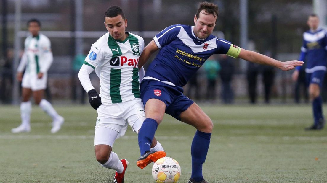 Daniel van Kaam namens Jong FC Groningen in duel met Harkemase Boys-aanvoerder Henny Bouius