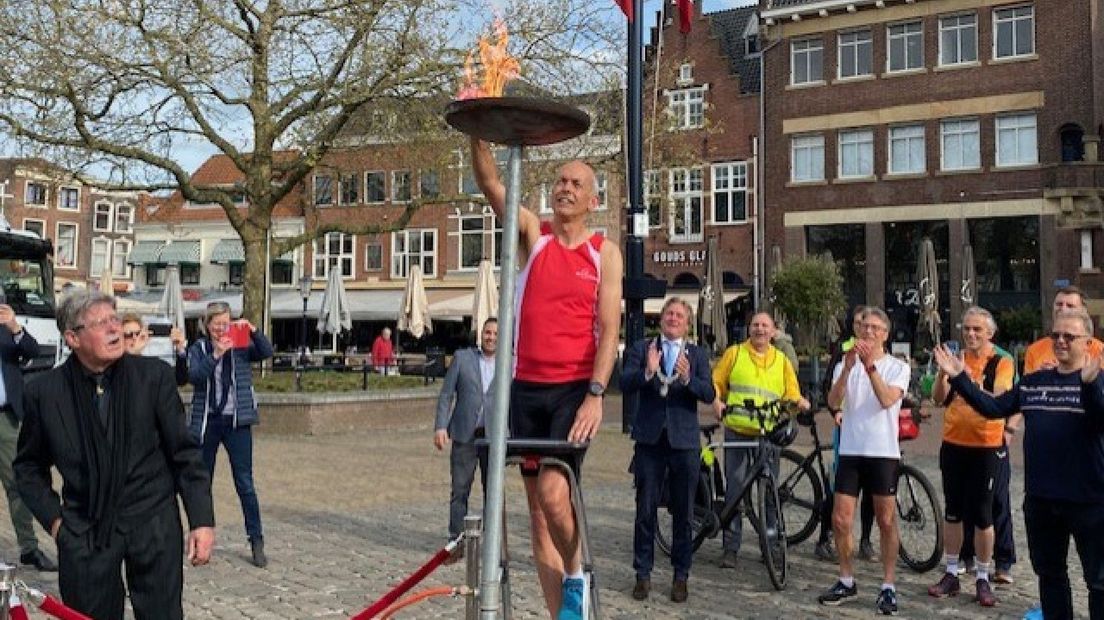 Een estafetteloper laat het bevrijdingsvuur in Gouda branden