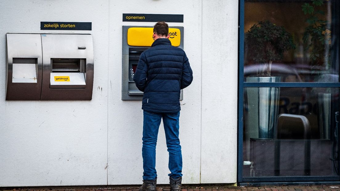 Iemand pint geld bij een Geldmaat-bankautomaat