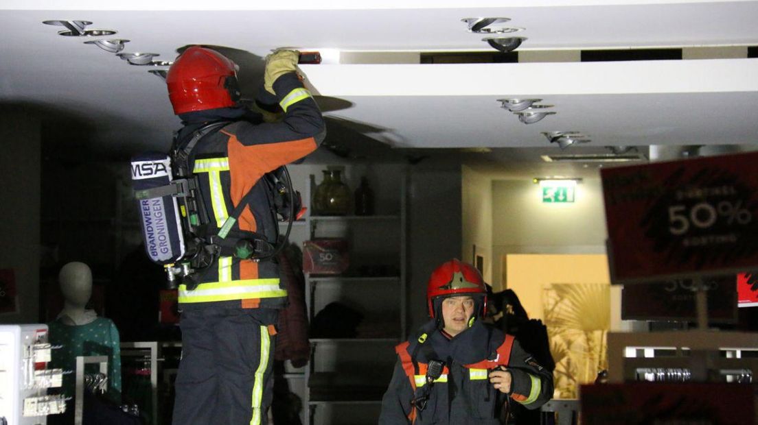 Brandweerlieden inspecteren het plafond.