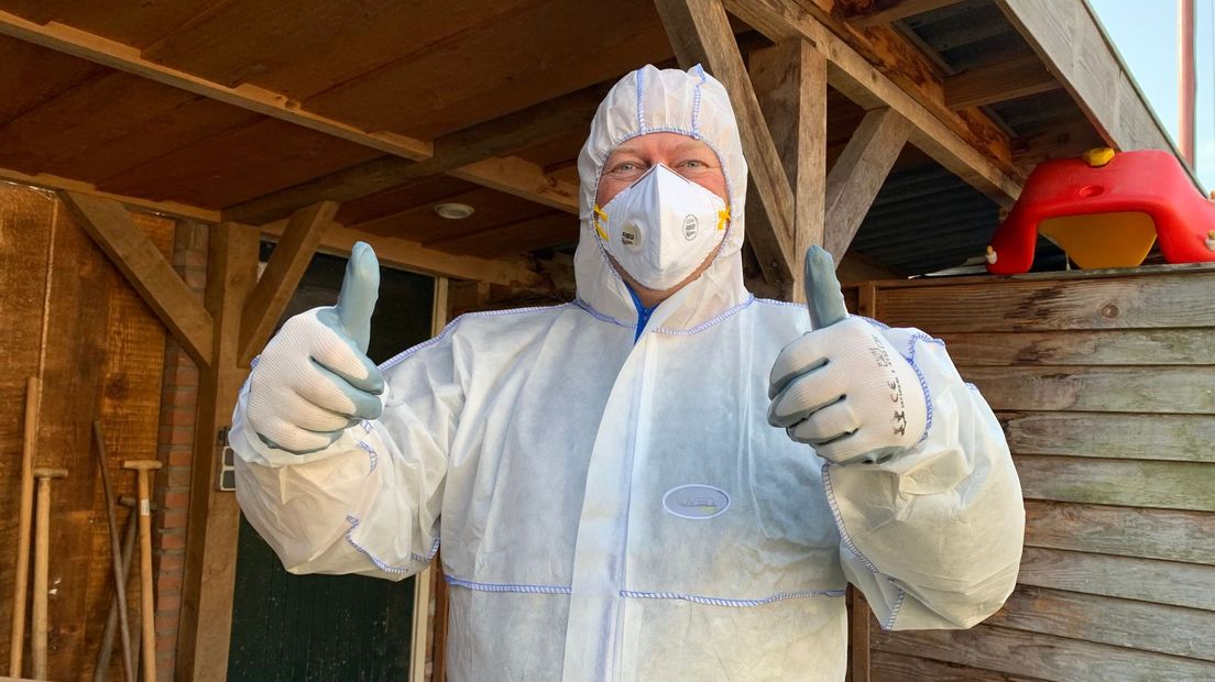 Erik de Vries is veilig ingepakt om asbest van het schuurdak te verwijderen