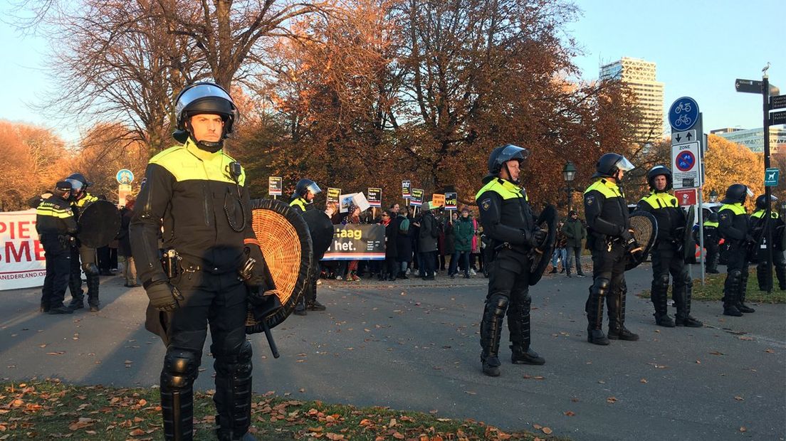 De Mobiele Eenheid staat opgesteld om voor- en tegenstanders van Zwarte Piet uit elkaar te houden
