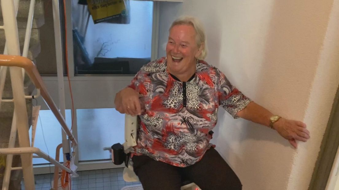 Een heel blije Nel Wensveen met de nieuwe traplift I