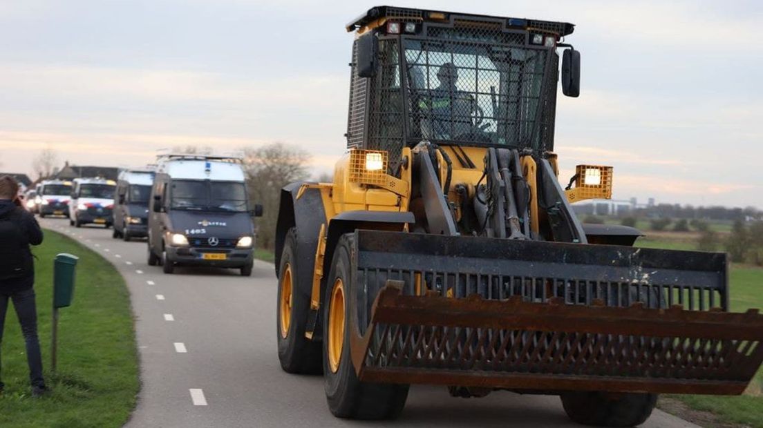 De shovel van de ME voert de stoet van ME- en arrestatiebusjes aan.