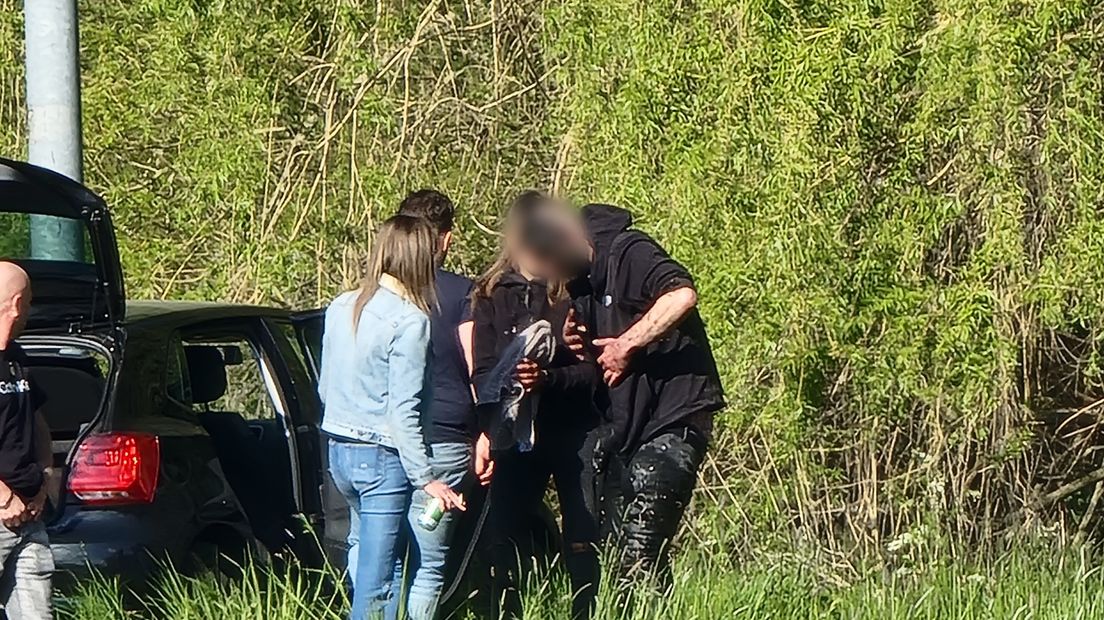 Een supporter van Heracles Almelo zit onder het slib nadat hij in een sloot belandde