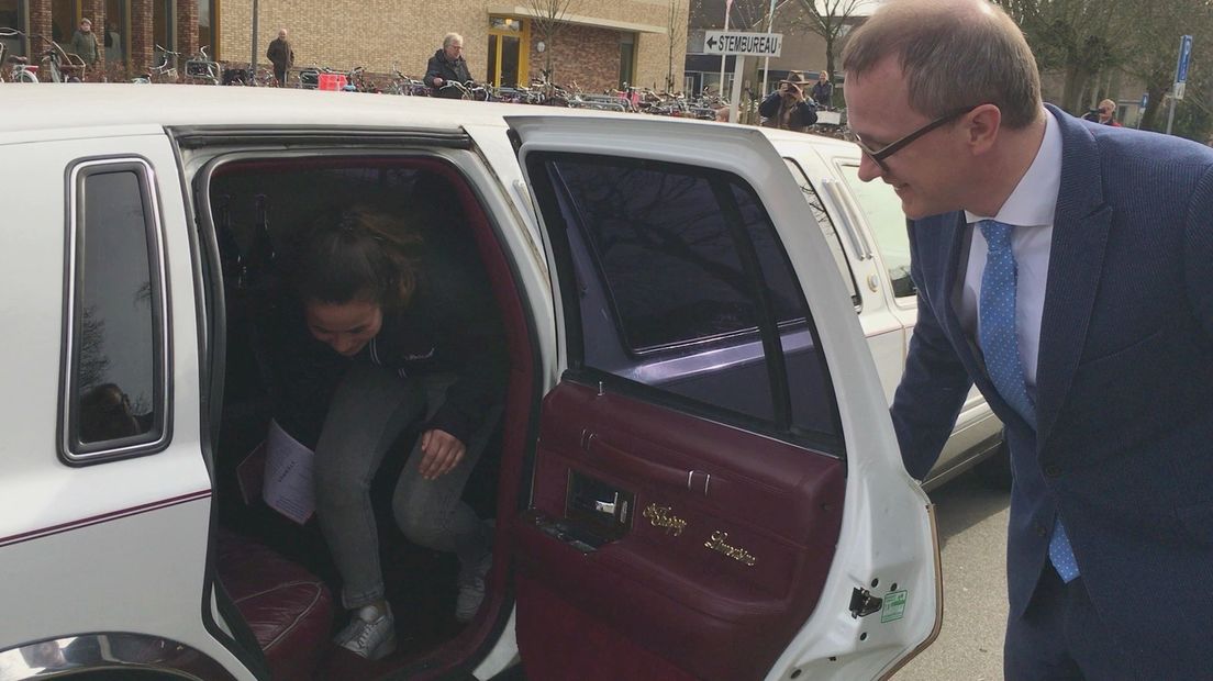 Burgemeester Sijbom brengt debuterende stemmers naar het stembureau in een limousine