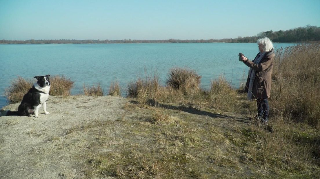 Klaartje Duijm en haar hond voor de plas waar zonnepanelen op komen