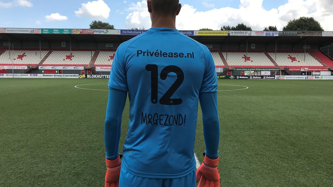 Kjell Scherpen toont het shirt met de nieuwe sponsor (Rechten: FC Emmen)