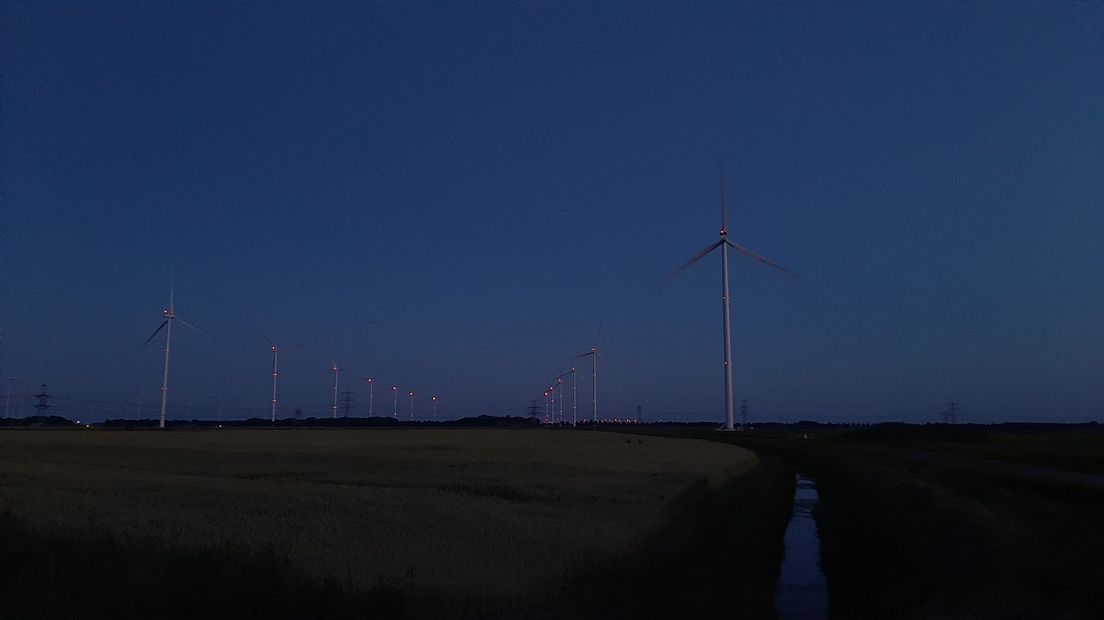 Windmolens in het donker met rode verlichting