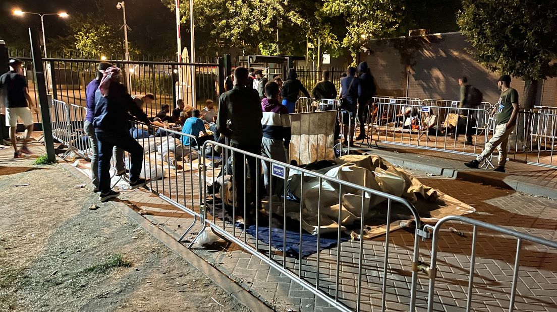 Een groep asielzoekers ligt uit protest pal voor de poort in Ter Apel