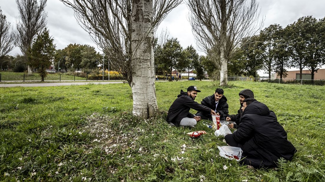 Asielzoekers picknicken bij het aanmeldcentrum in Ter Apel