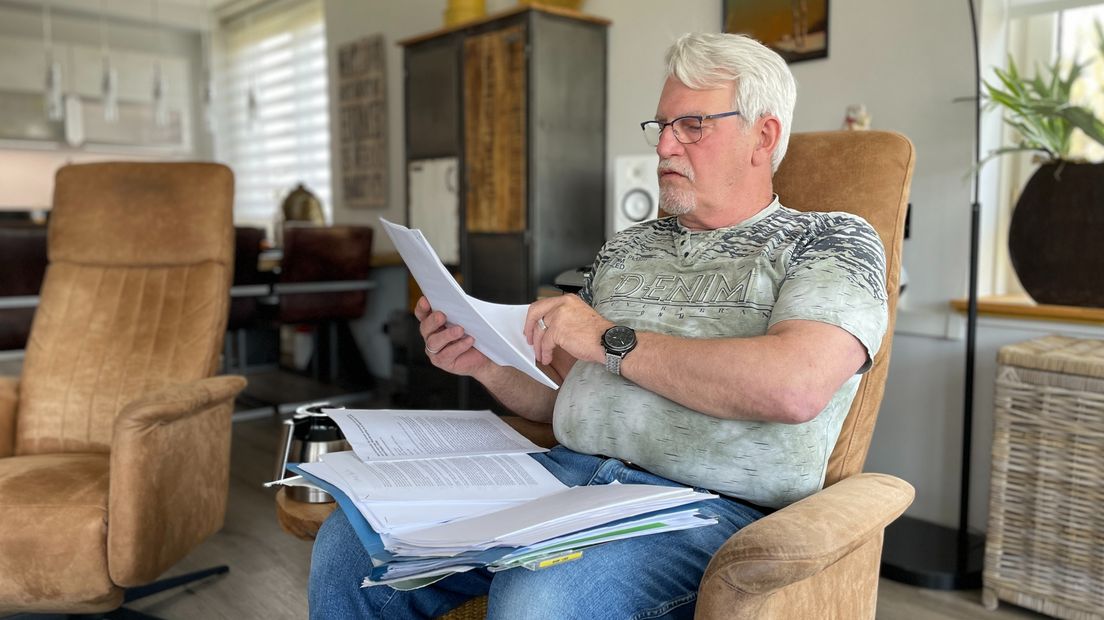 Hans Hoven bladert door het papierwerk van zijn oude huis