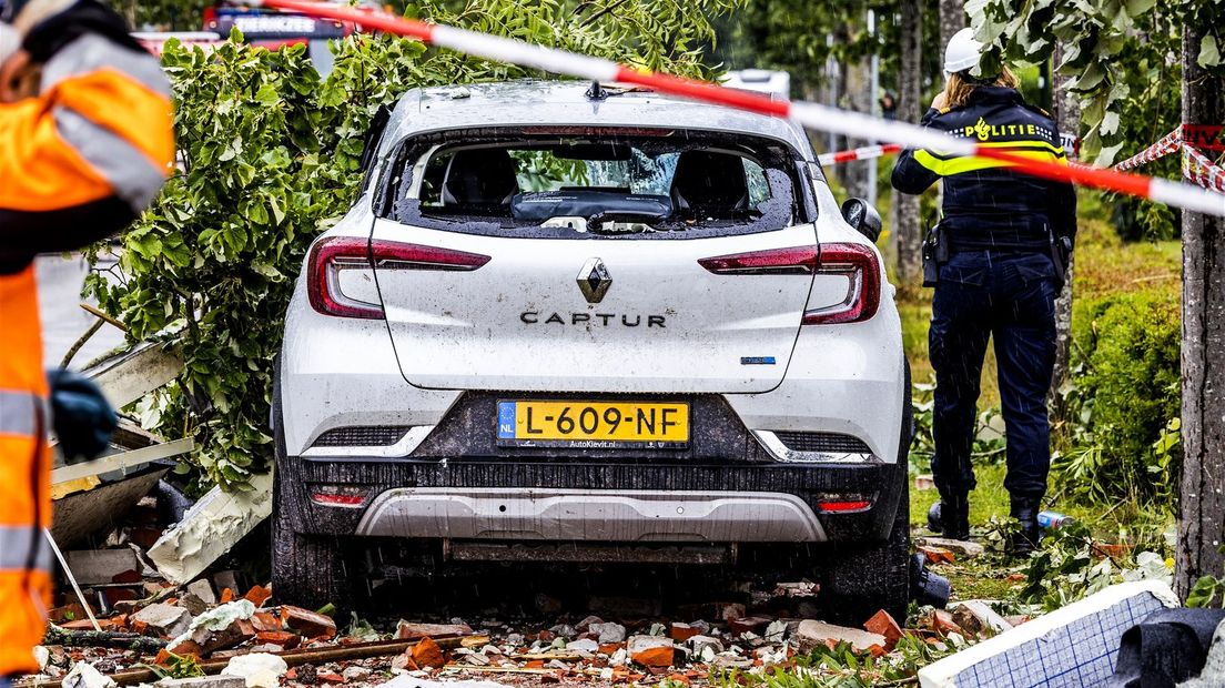 De witte auto is zwaar beschadigd na de tornado in Zierikzee