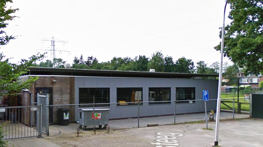 De kinderopvang met op de achtergrond de hoogspanningsmast.
