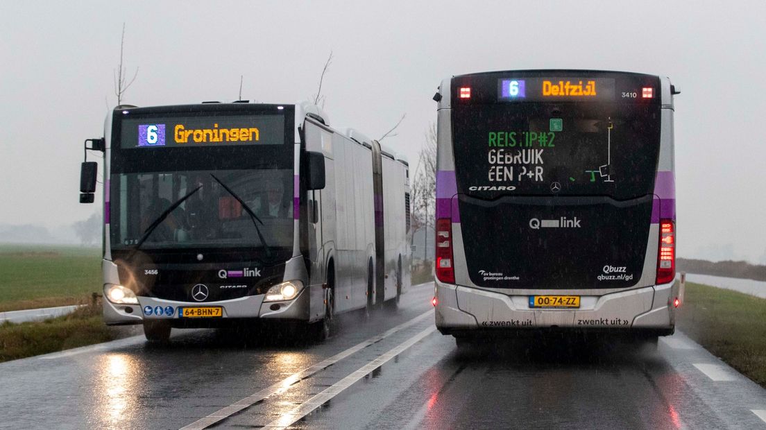 Twee bussen passeren elkaar op een regenachtige dag