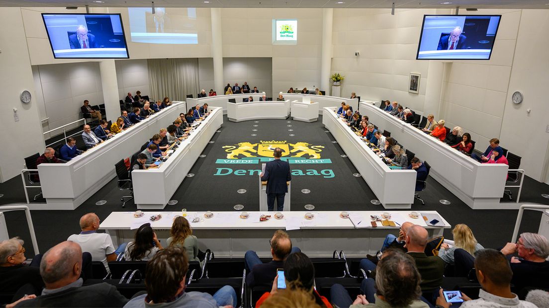 Haagse gemeenteraad vergadert in raadzaal.