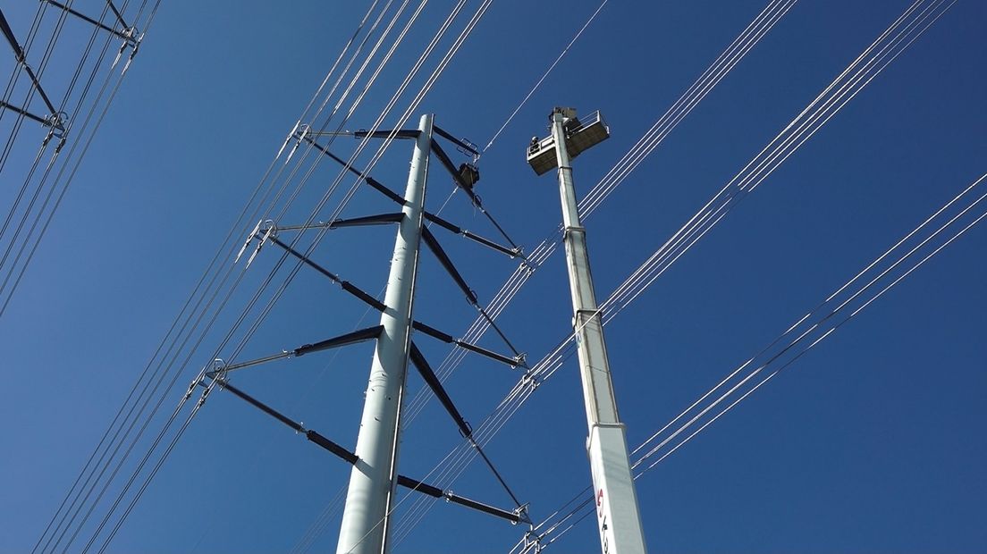 Een hoogwerker naast één van de pylonen
