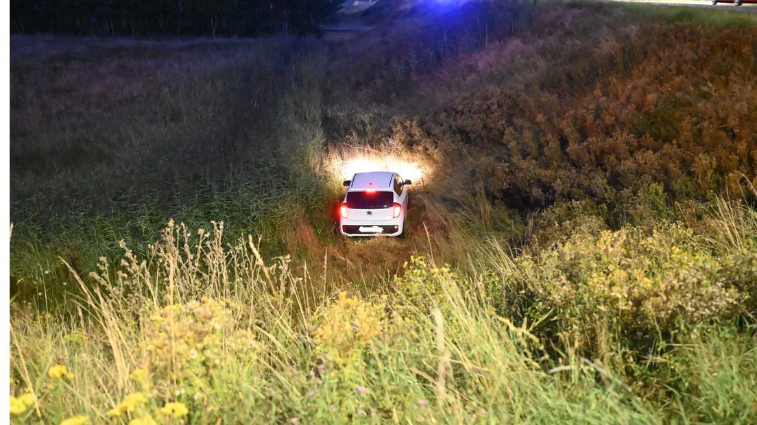 Auto raakt van de weg en belandt onder aan het talud