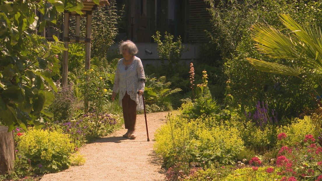 Grace Seeman wandelt door de binnentuin vol met bloemen
