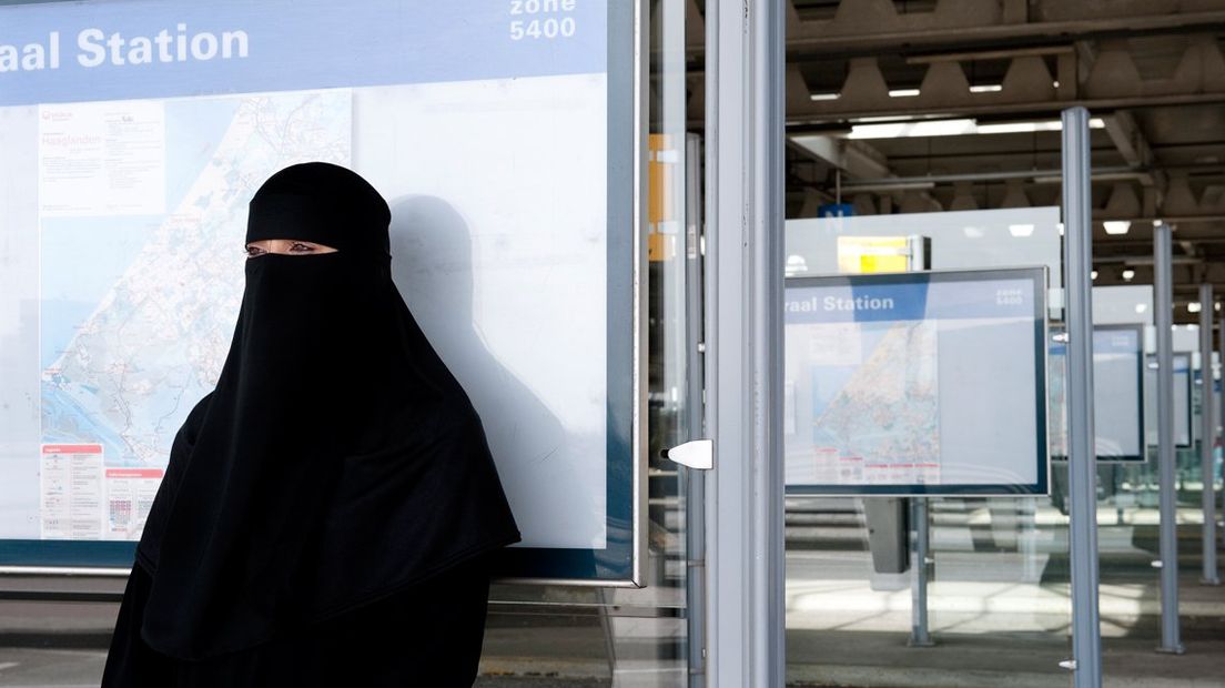 Vrouw in niqab wacht op de bus .