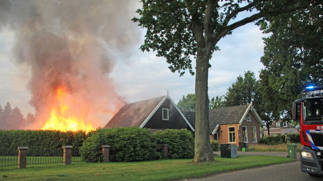 De brandweer probeert te voorkomen dat het vuur overslaat naar de woning