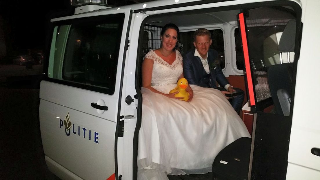 Het kersverse bruidspaar in de politieauto