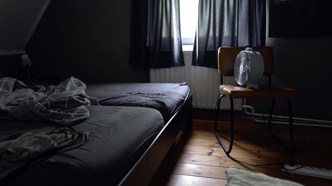 Een slaapkamer met een ventilator