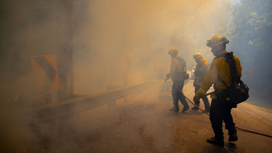 Brandweermannen blussen in de omgeving van Pots huizen de brand (Rechten: ANP/EPA)