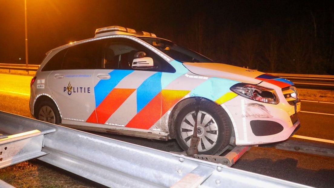 De beschadigde politieauto wordt afgesleept.