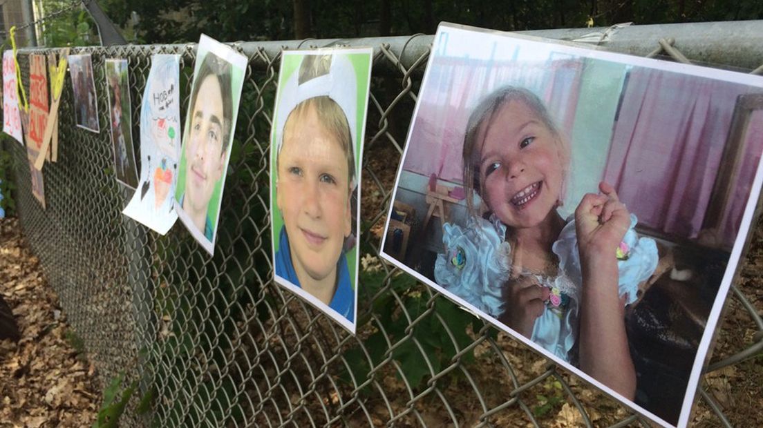Aan het hek bij het detentiecentrum hangen foto's van de kinderen uit het gezin.