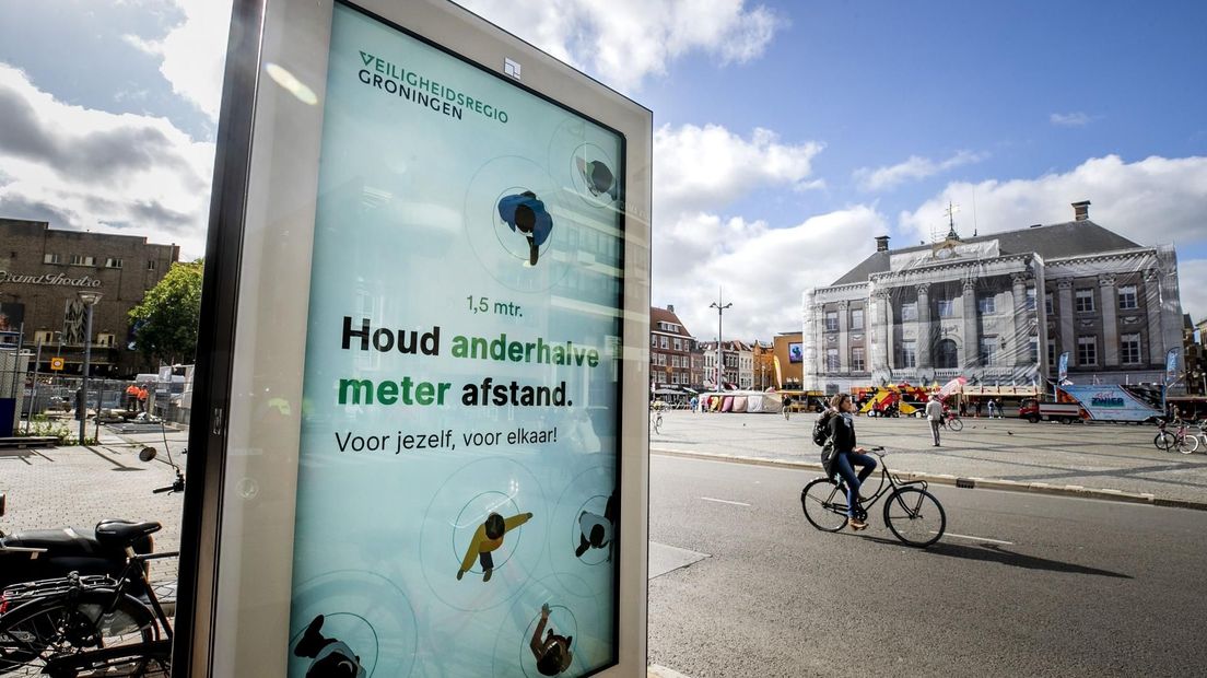 Een informatiebord op de Grote Markt herinnert passanten aan de anderhalvemeterregel.