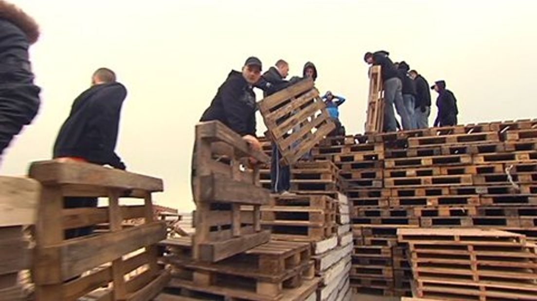 Pallets stapelen voor de opbouw van het vreugdevuur in Scheveningen.