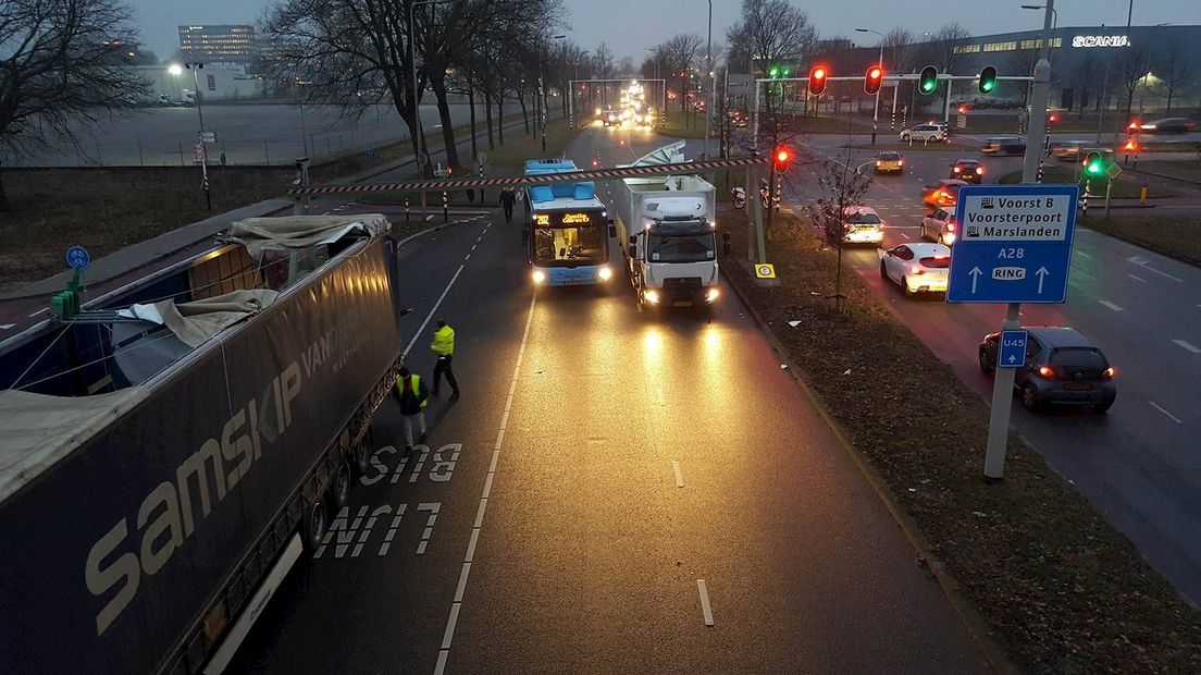Twee vrachtauto's en bus rijden tegen hoogtebalk