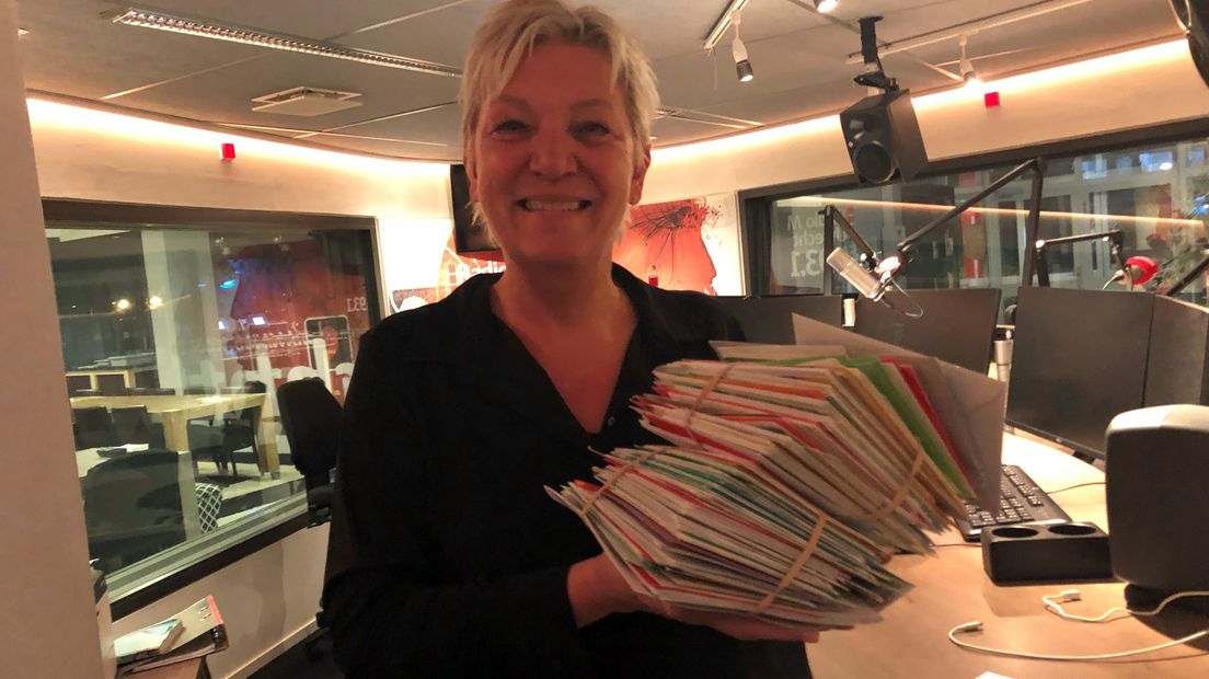 Radiopresentatrice Maya Eksteen met een aantal kaarten voor weerman Arie.