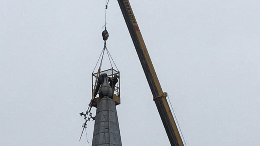 Een gespecialiseerd bedrijf demonteert de torenspits 