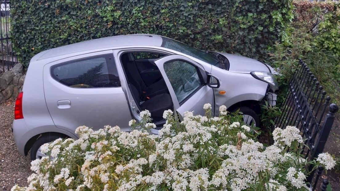Auto belandt na botsing in tuin van woning in Enter