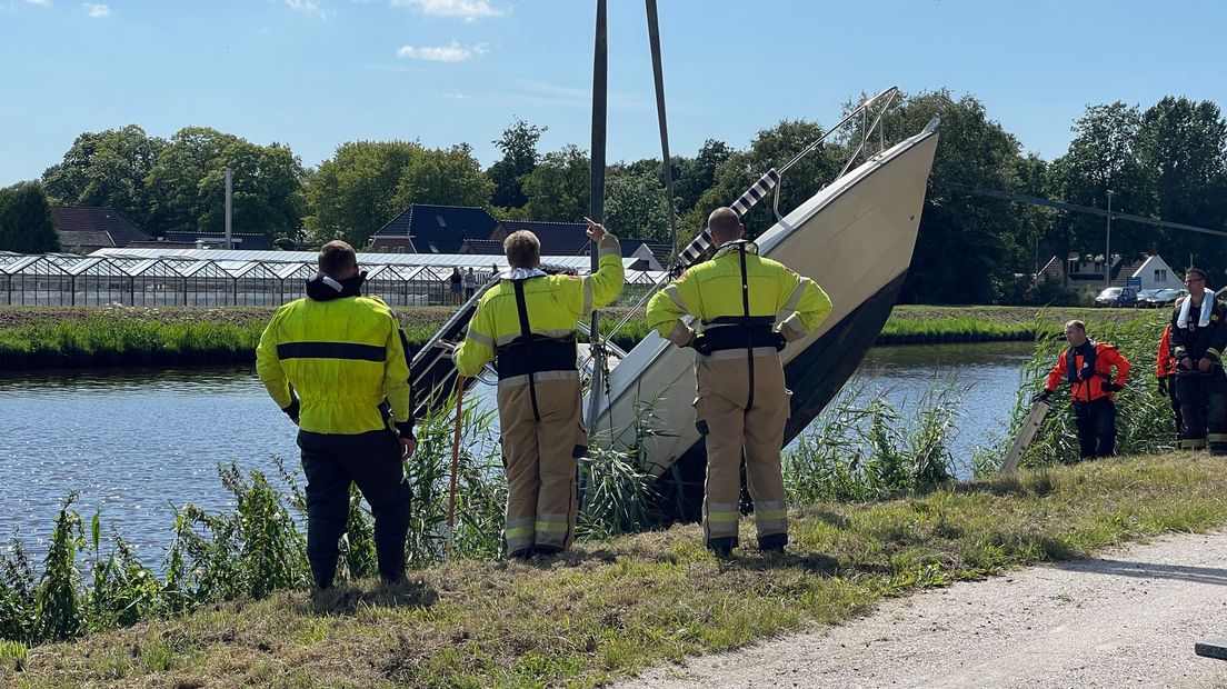 De brandweer takelt het bootje uit het Winschoterdiep