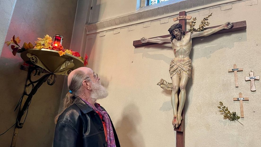 De restaurateur bekijkt het door hem opgeknapte Christusbeeld